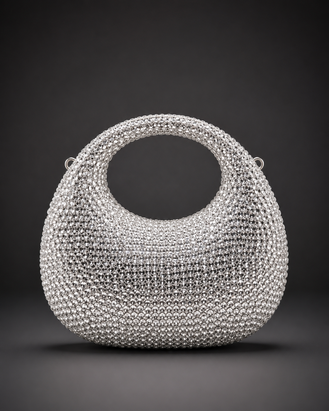 Saira silver crystal halo handbag with an integrated oval handle and rounded embellished body.