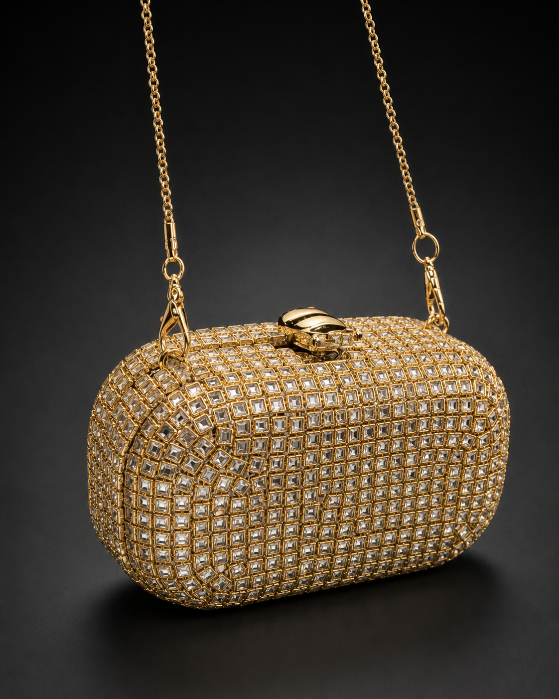 Elara champagne-gold rounded box clutch with square crystal-effect facets, top clasp and fine chain.